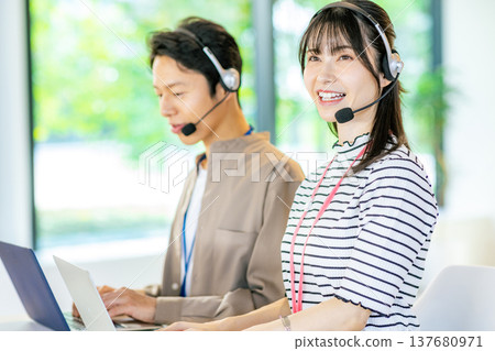 Male and female operators working in the office 137680971