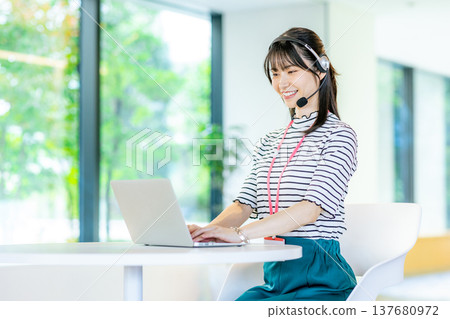 在呼叫中心工作的年輕女子 在呼叫中心工作的年輕女子 137680972