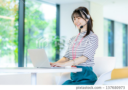 在呼叫中心工作的年輕女子 在呼叫中心工作的年輕女子 137680973