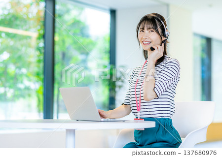 在呼叫中心工作的年輕女子 在呼叫中心工作的年輕女子 137680976