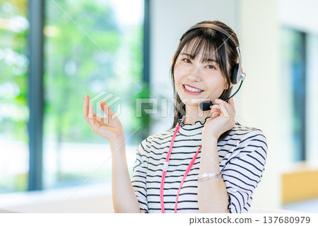 在呼叫中心工作的年輕女子 在呼叫中心工作的年輕女子 137680979