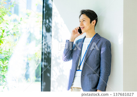 一名身穿夾克、正在使用智慧型手機的男子 137681027
