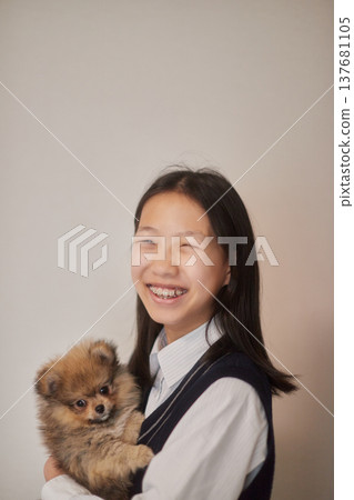 一名國中女生在客廳和小狗玩耍。 137681105