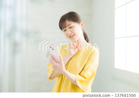 觀看智能手機的婦女 觀看智能手機的婦女 137681500