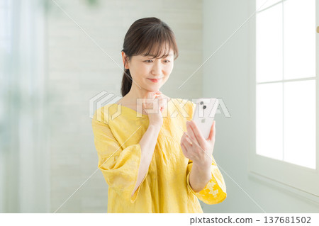 觀看智能手機的婦女 觀看智能手機的婦女 137681502