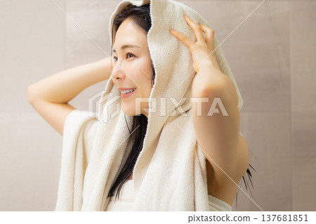 一位女士在浴室裡做頭髮護理。 一位女士在浴室裡做頭髮護理。 137681851