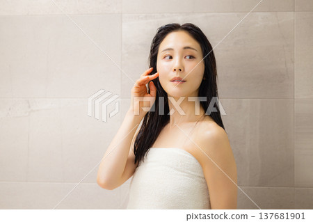 一位女士在浴室裡進行護膚和頭髮護理。 一位女士在浴室裡進行護膚和頭髮護理。 137681901