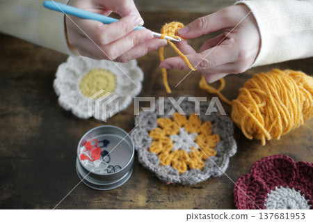 一位婦女的雙手和她用羊毛編織的作品 一位婦女的雙手和她用羊毛編織的作品 137681953