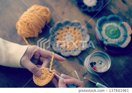 一位婦女的雙手和她用羊毛編織的作品 一位婦女的雙手和她用羊毛編織的作品 137681961