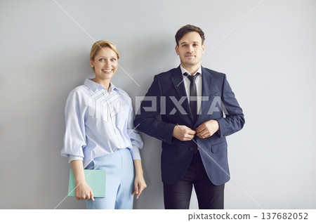 Portrait of confident business colleagues standing side by side and smiling at camera. 137682052