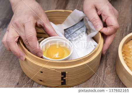 Prepare to make steamed breakfast in the kitchen using a bamboo steamer. 137682165