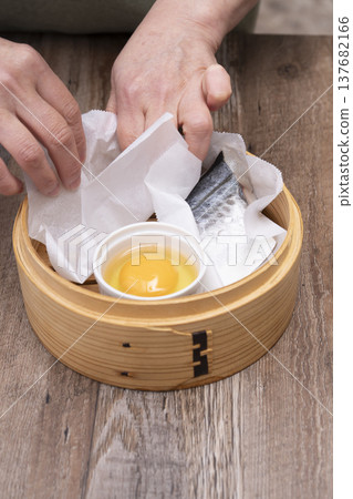 Prepare to make steamed breakfast in the kitchen using a bamboo steamer. 137682166