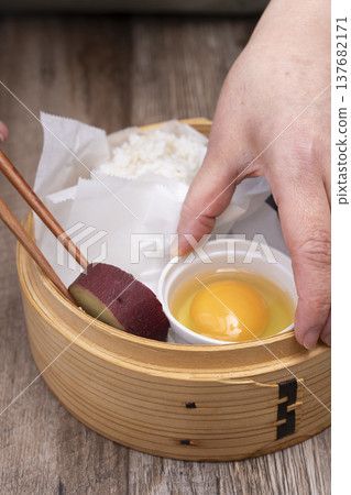 Prepare to make steamed breakfast in the kitchen using a bamboo steamer. 137682171
