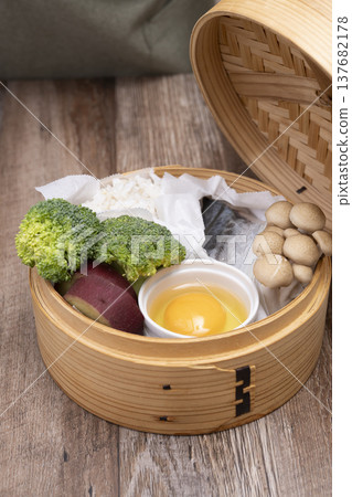 Prepare to make steamed breakfast in the kitchen using a bamboo steamer. 137682178