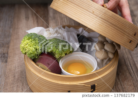 Prepare to make steamed breakfast in the kitchen using a bamboo steamer. Prepare to make steamed breakfast in the kitchen using a bamboo steamer. 137682179