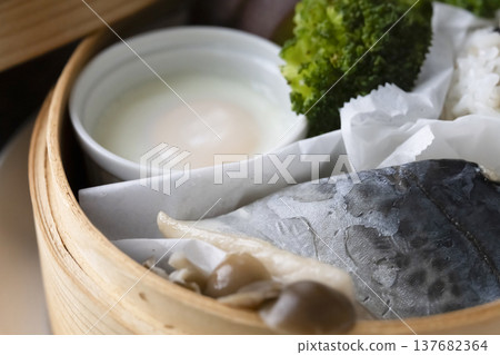 Steamed breakfast in a bamboo steamer; photographed in natural light. Steamed breakfast in a bamboo steamer; photographed in natural light. 137682364