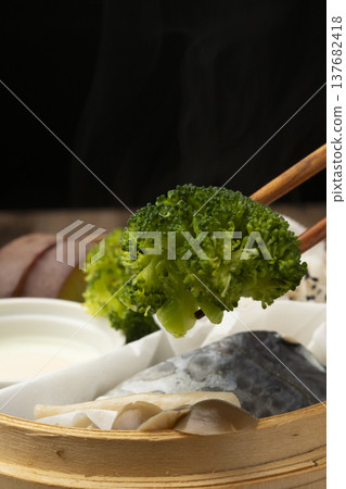 用竹蒸籠蒸煮的早餐，用筷子夾起來吃。 137682418