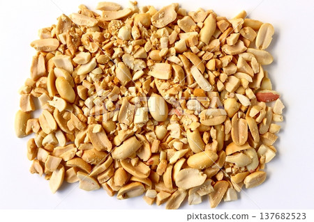 Crushed peanuts against a white background, viewed from directly above. Crushed peanuts against a white background, viewed from directly above. 137682523