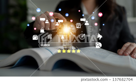 Concept of Digital Marketing Strategy with Light Bulb and Various Social Media Icons Over Open Book for Effective Knowledge Sharing and Learning Quark 137682704