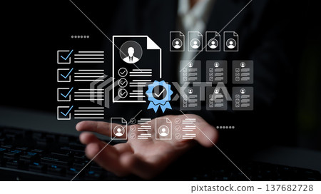 Business professional holding floating resume and checklist icons, representing job applications and candidate evaluations in modern workspace Gantry 137682728