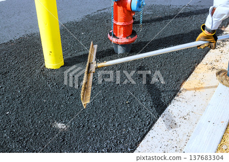 Workers repair pave street with asphalt near fire hydrant in busy urban area 137683304