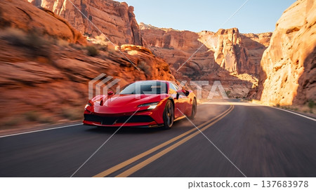 一輛豪華轎車沿著風景優美的公路飛馳穿過荒野，背景也隨之快速移動，給人一種速度感。 137683978