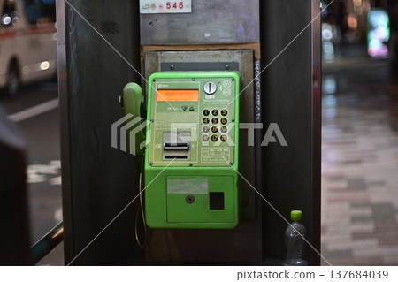 夜裡,街角架起了一部綠色的公用電話。 夜裡,街角架起了一部綠色的公用電話。 137684039