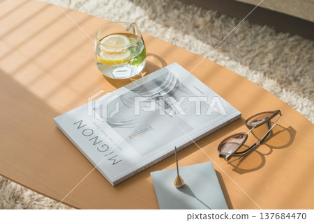 客廳的桌子上放著排毒水、雜誌和太陽眼鏡。 137684470