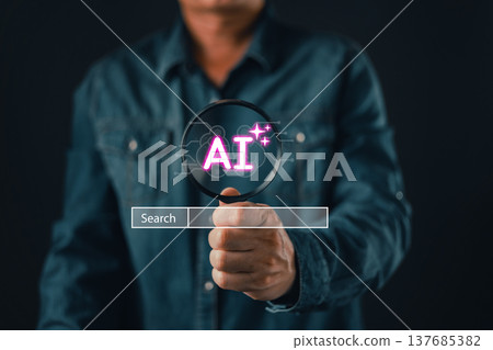 A person holds a magnifying glass focusing on a glowing AI symbol above a search bar, representing artificial intelligence discovery, digital innovation, and technology research exploration. 137685382