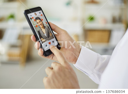 Person using smartphone dating app to like a profile with heart icon closeup Person using smartphone dating app to like a profile with heart icon closeup 137686034
