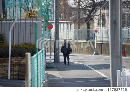 冬日的清晨,一位老人走過城市的居民區。 冬日的清晨,一位老人走過城市的居民區。 137687736