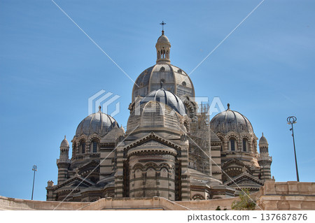 Domes and towers of the Marseille Cathedral of Sainte-Marie-Majeure in the La Joliette district, neo-Byzantine architecture under a blue sky 137687876