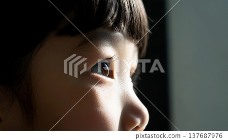 孩子側臉望向窗外，特寫鏡頭聚焦在他的眼睛。 137687976