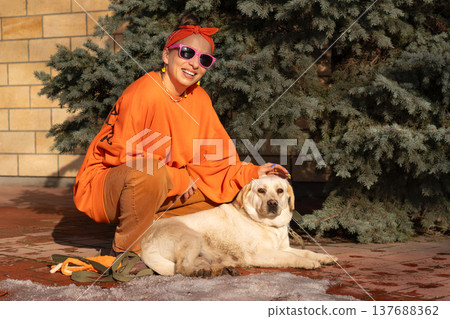 Woman Sitting Beside Labrador Dog On Park Path Woman Sitting Beside Labrador Dog On Park Path 137688362