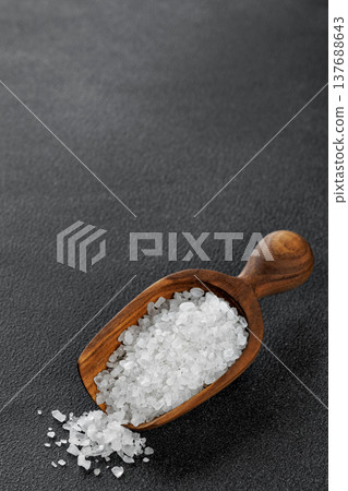 sea salt crystals in wooden scoop on black background sea salt crystals in wooden scoop on black background 137688643