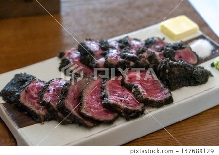 Set of Black Gyukatsu or beef cutlet served with butter. A traditional Japanese food that consists of a deep-fried beef cutlet. Set of Black Gyukatsu or beef cutlet served with butter. A traditional Japanese food that consists of a deep-fried beef cutlet. 137689129