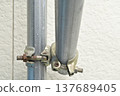 Right-angle clamps and rusted bolts used to secure single-pipe scaffolding. 137689405