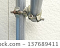 Close-up of a horizontal view of scaffolding pipes and adjustable clamps used at a construction site. 137689411