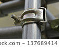 Close-up of a clamp used to secure a single pipe: Standard markings and the texture of the bolt. 137689414