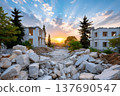 Destroyed white buildings with rubble pile at sunset representing hope 137690547