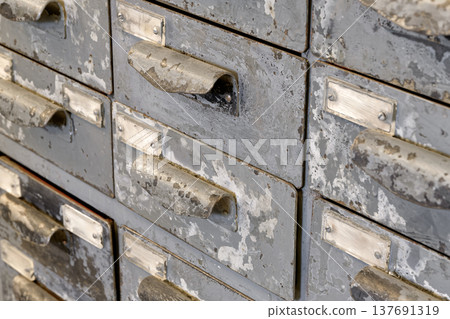 Very old grey metal cabinet with multiple drawers - cards, files, tools or fasteners storage unit 137691319