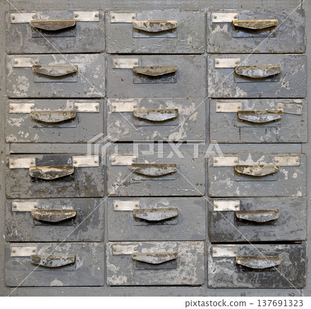 Very old grey metal cabinet with multiple drawers - cards, files, tools or fasteners storage unit 137691323