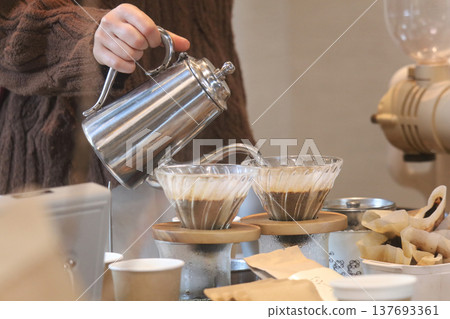 A woman who is making coffee 137693361