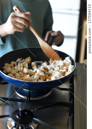 I'm making bread crust rusks by frying chopped bread crusts in a pan. 137694510