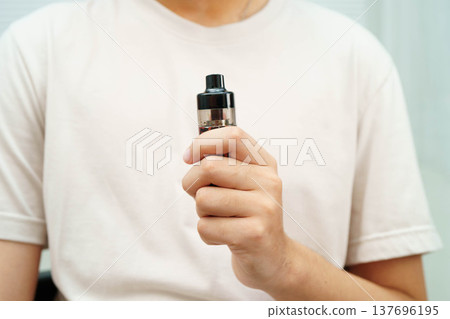Man holding electronic cigarettes, no smoking. Man holding electronic cigarettes, no smoking. 137696195