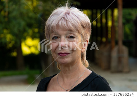 Portrait of 65-70 year old senior woman outdoors in park Portrait of 65-70 year old senior woman outdoors in park 137696254