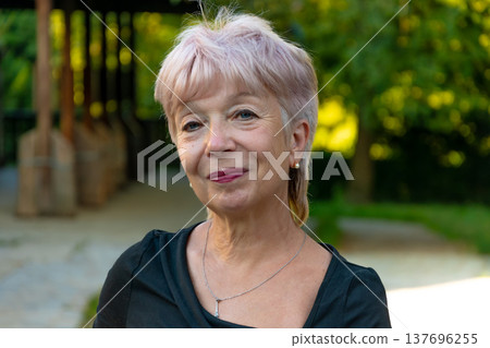 Senior woman 65 years old standing in park looking at camera Senior woman 65 years old standing in park looking at camera 137696255