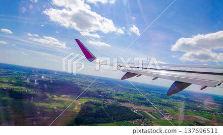 Wings cut through blue sky with scattered clouds 137696511