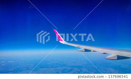 Plane wing glides above fluffy white clouds 137696541