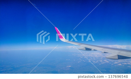 Plane wing glides above fluffy white clouds 137696548